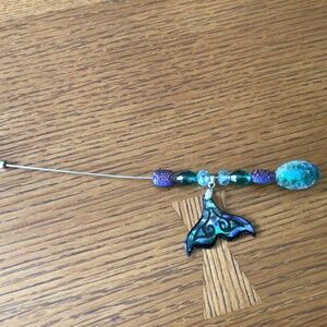 Beaded hat pin with fish tail ornament.